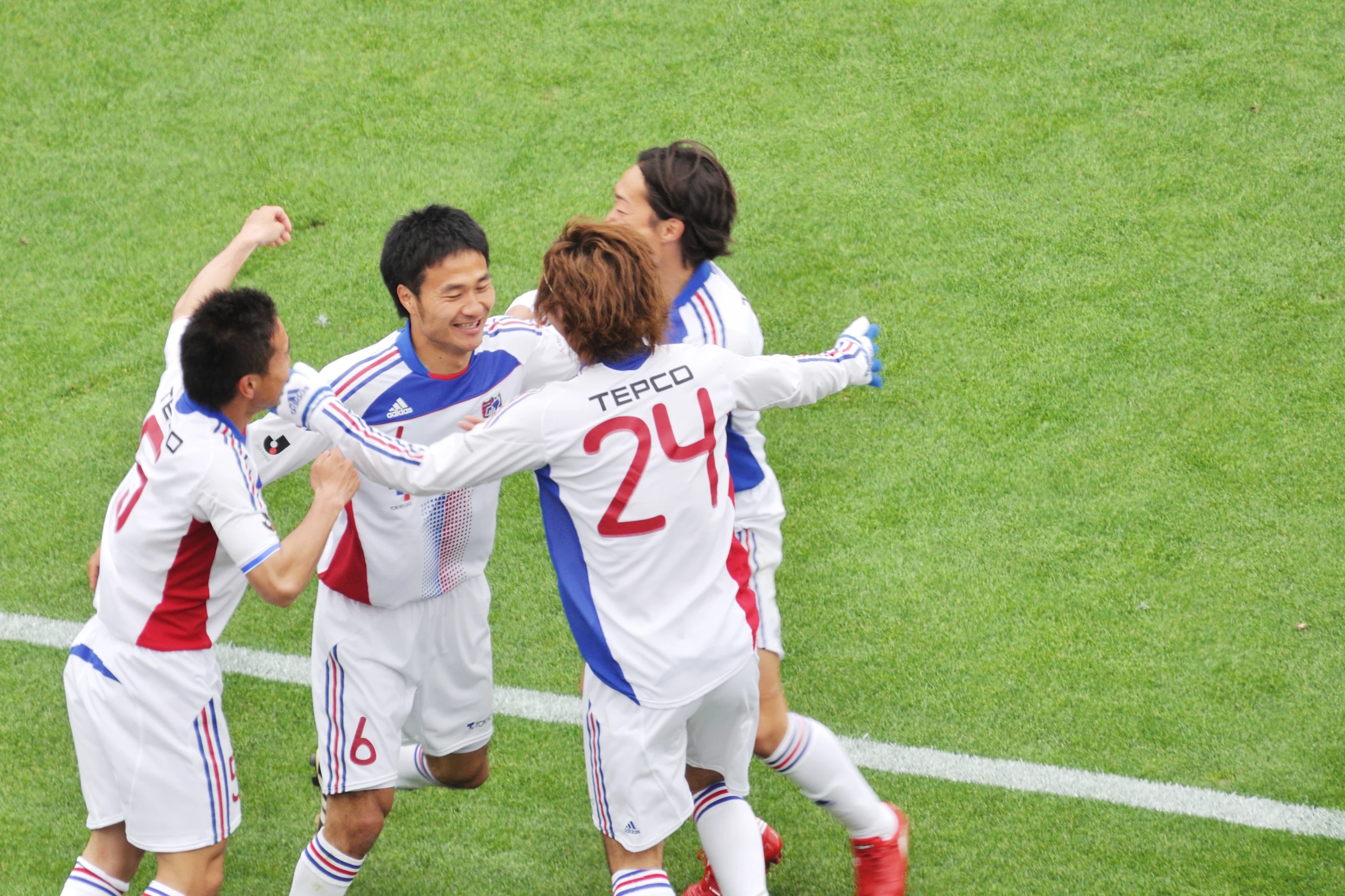 soccer players in uniforms standing on a field