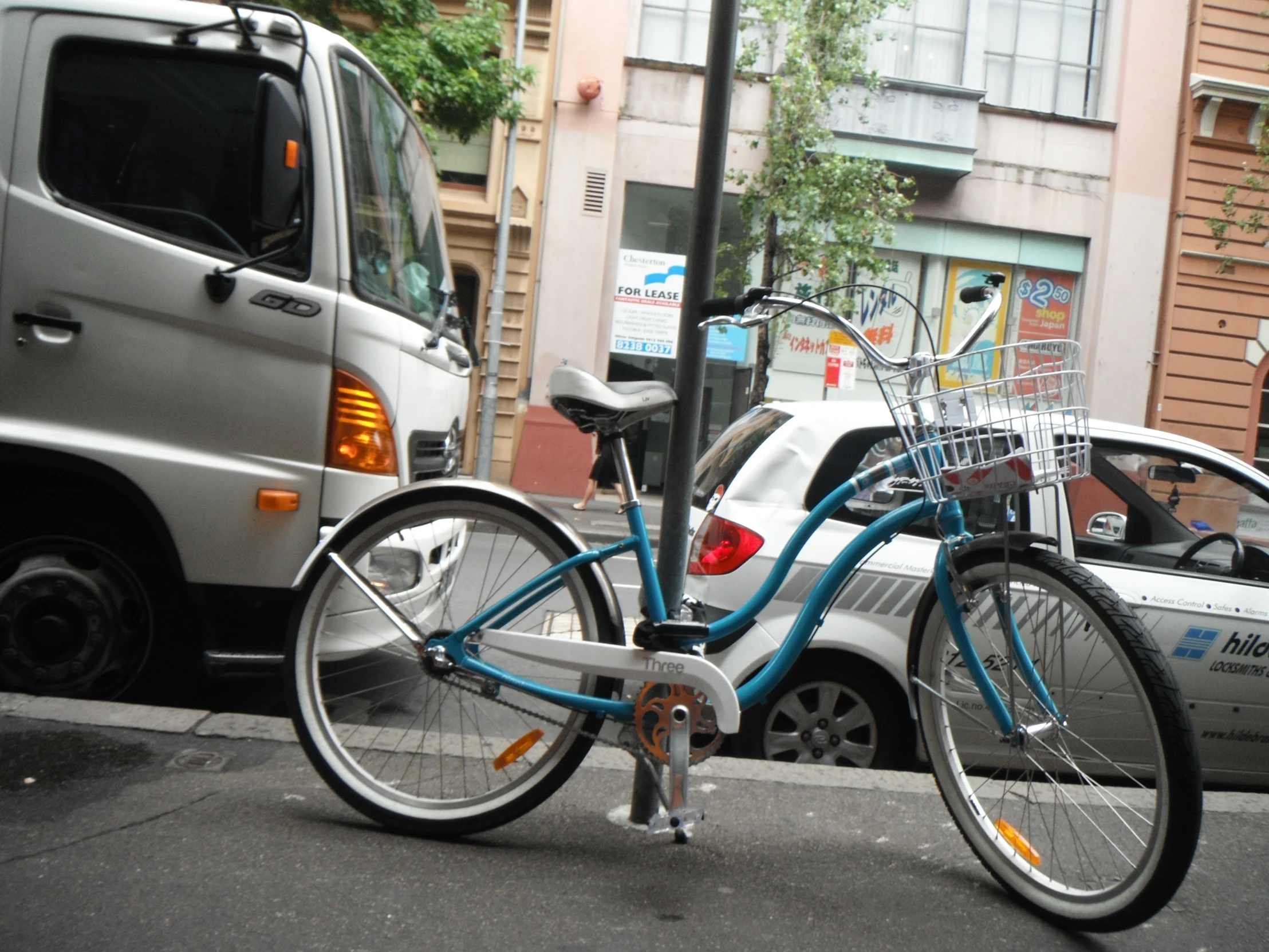 a parked blue bicycle on the side of a road