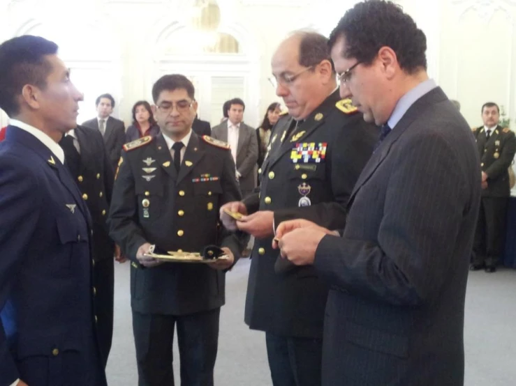 two men in suits and one wearing military medals