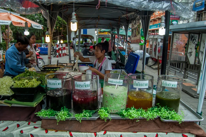 many containers of food on a table in a marketplace