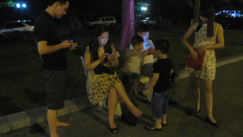a man looking at his phone as a group of people look on