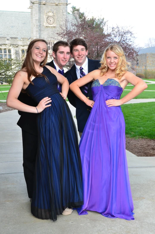 the young man and women are posing for a picture in front of their high school prom gowns