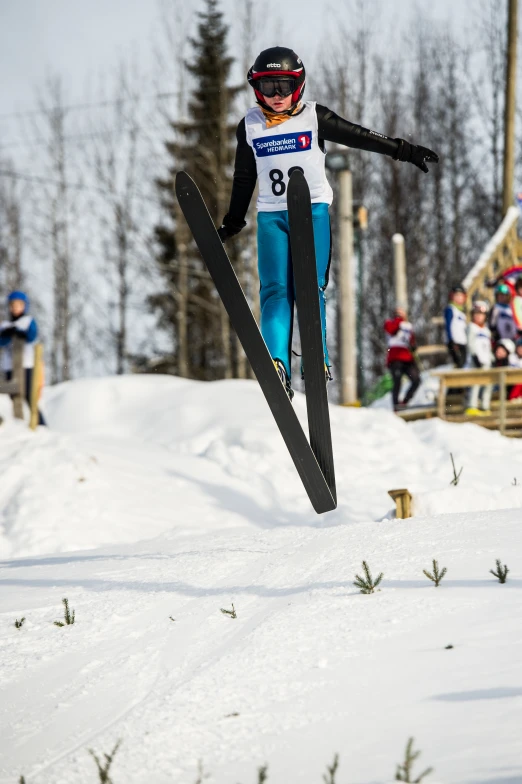 the woman is jumping on skis at the bottom of the slope