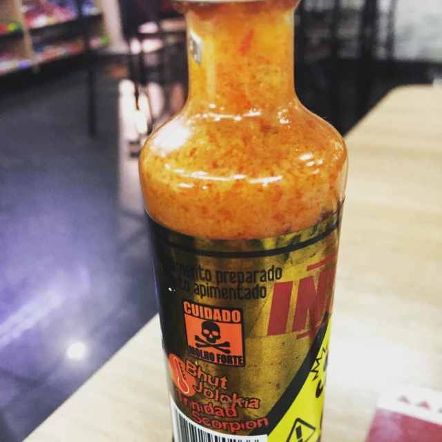 an empty bottle of food sitting on top of a wooden table