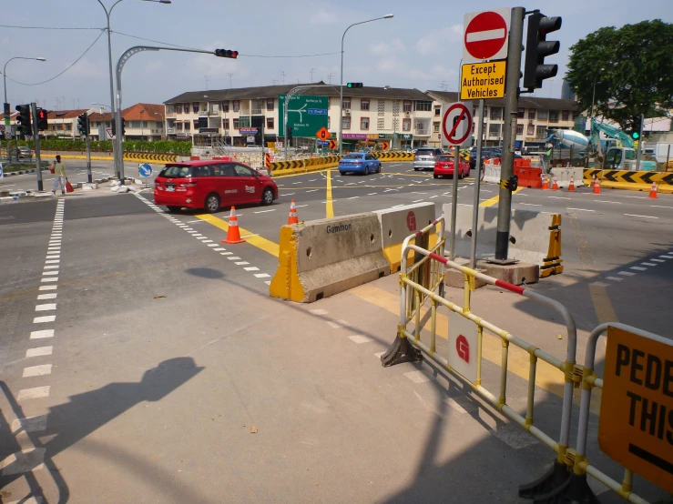 car stopped at stop light next to barrier across the street