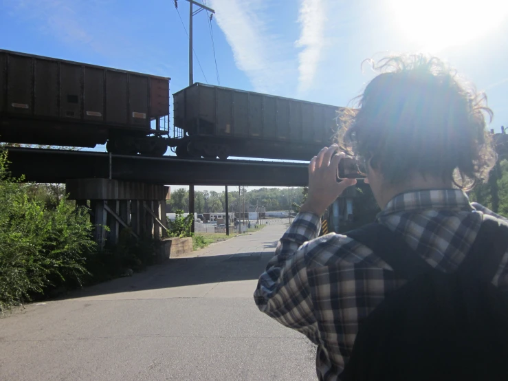 a man takes a po in front of a train bridge