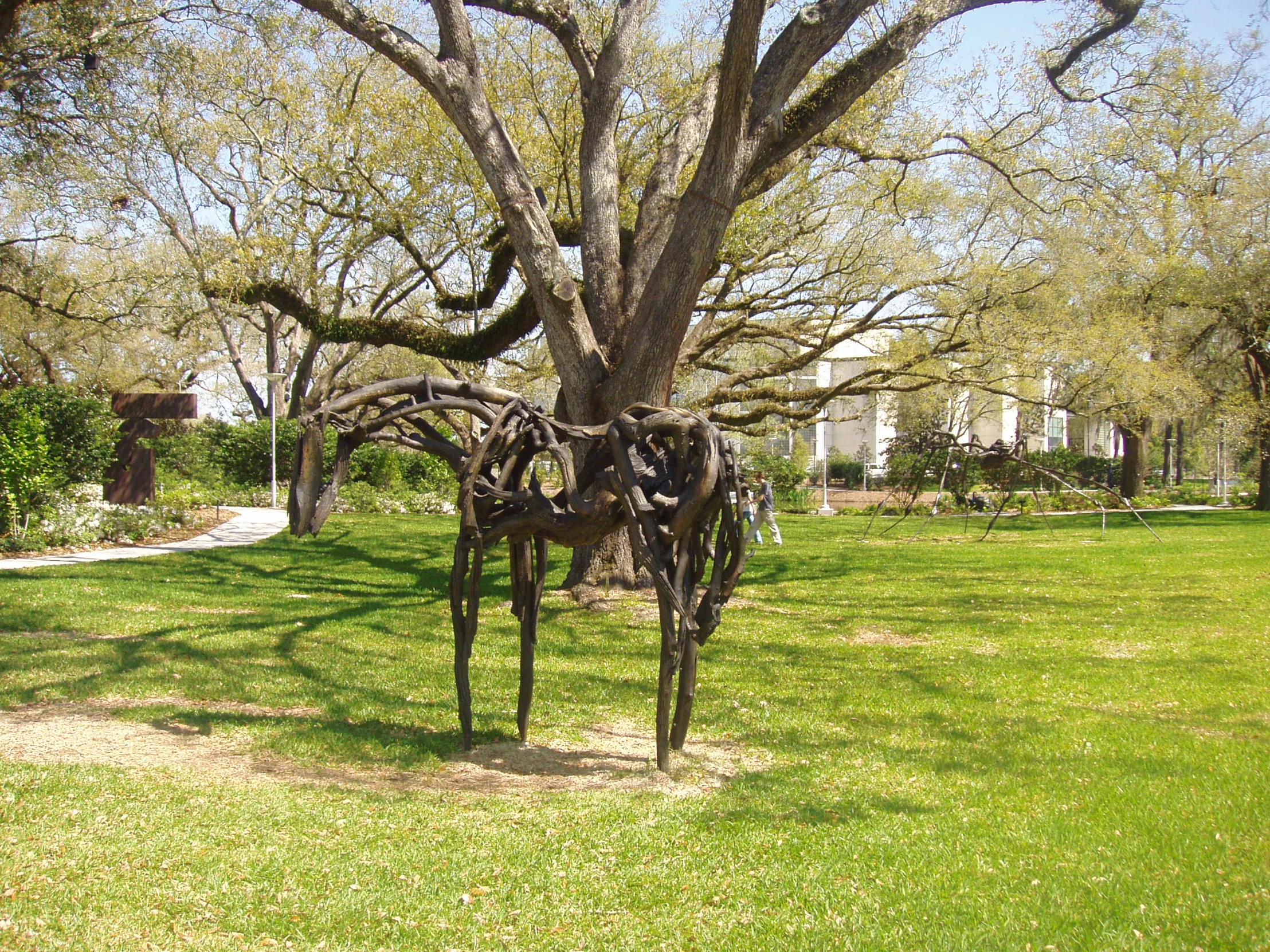 a sculpture in the shape of a erfly sitting underneath a tree