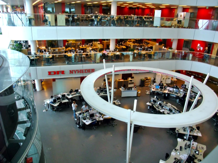 an atrium with people working and laptops on the tables