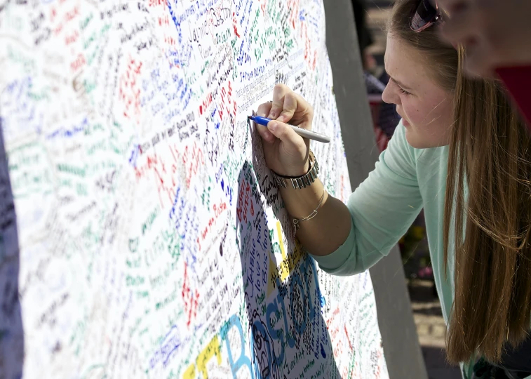 two girls standing by a large board full of writing