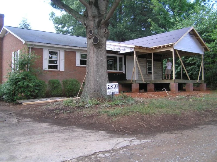 an outdoor brick home sitting under a tree