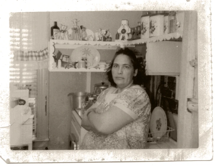 a lady in an old - fashioned kitchen is holding a pot of soup