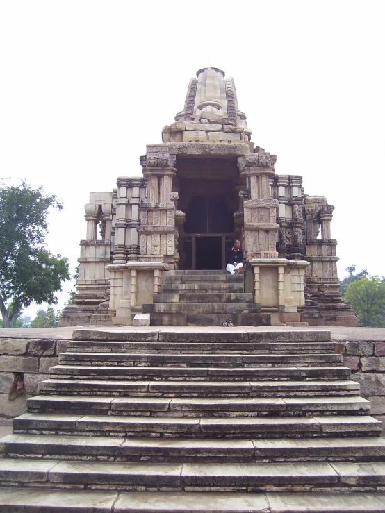 a person standing on a large stone structure near the steps