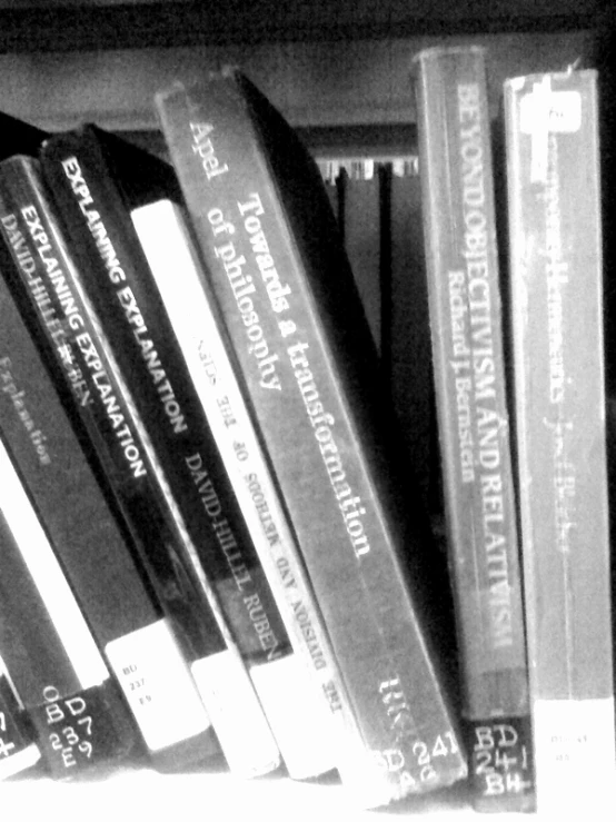 black and white books are on top of the bookshelves