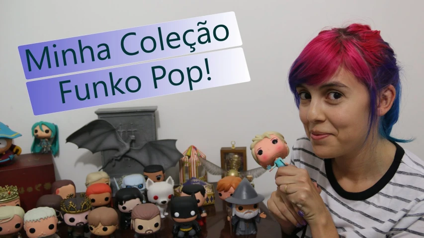 a girl wearing pink hair holds up a figurine next to a small collection of her favorite animated figures