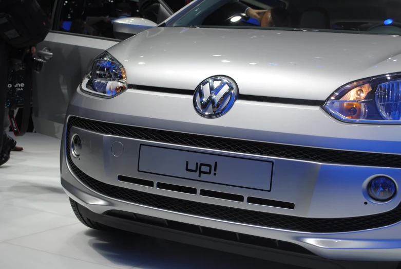 a silver volkswagen car with headlights on on display