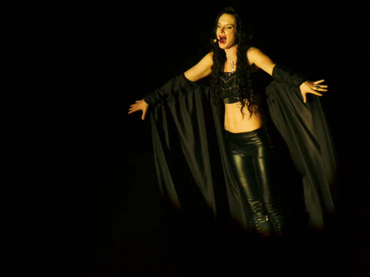 woman in leather pants standing and with a cape