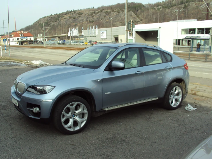 a gray bmw suv parked on the side of the street