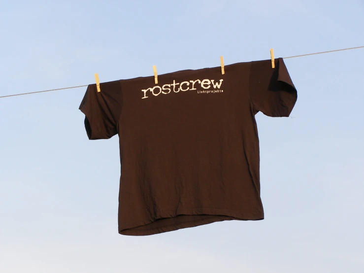 a t - shirt that reads rosterw hangs from a clothes line