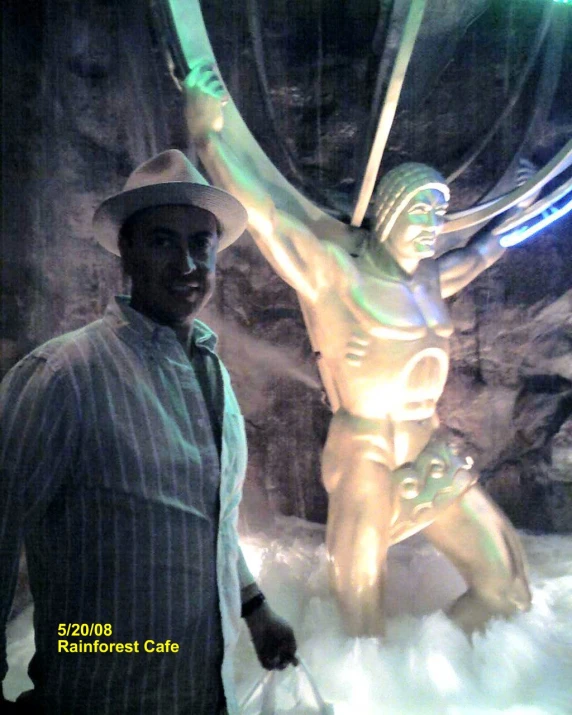 a man standing next to a lit up statue