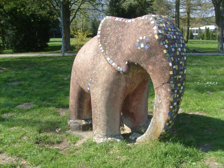 an elephant statue sitting in the middle of the park