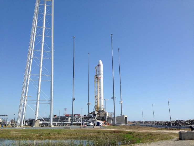 a large rocket that is on a platform next to some water