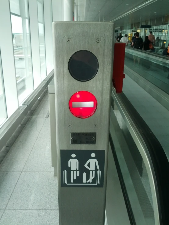 the floor of an airport has a grey metal post and sign indicating which way to go