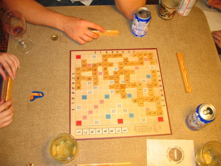 several people play a board game and drink beverages