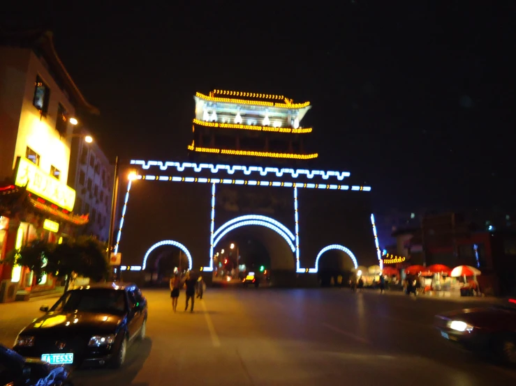 a dark night with several people walking on the side