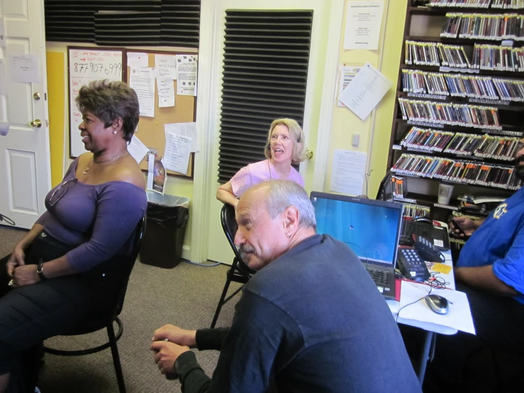 some people sitting in chairs by a large screen monitor