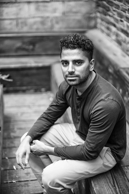 a young man sits on a bench and looks up