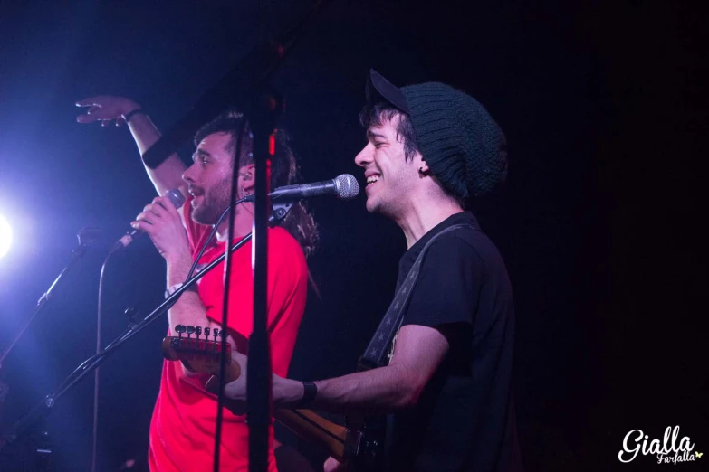 two men standing next to each other on stage with a microphone