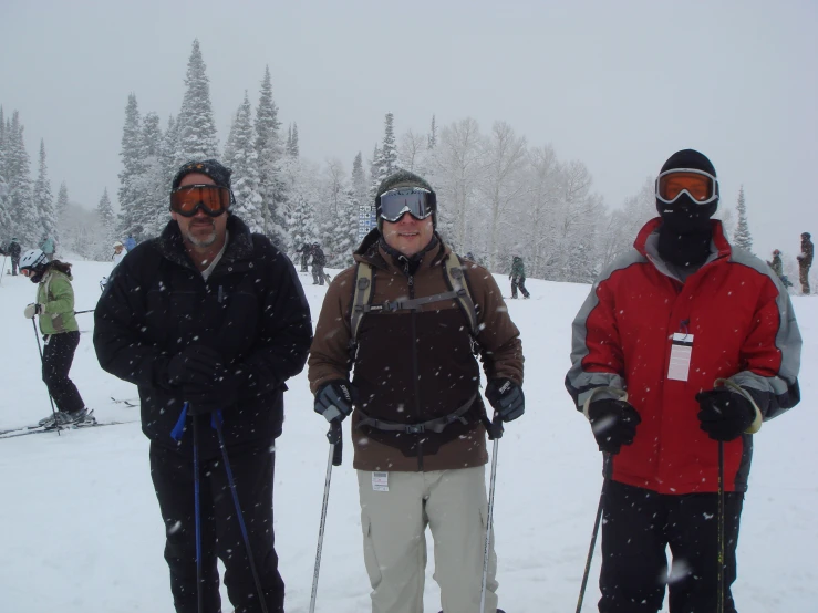 several people standing on skis, holding poles, and wearing snow gear