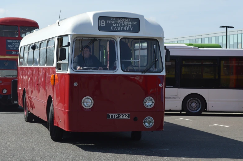 three different types of buses in parking lot