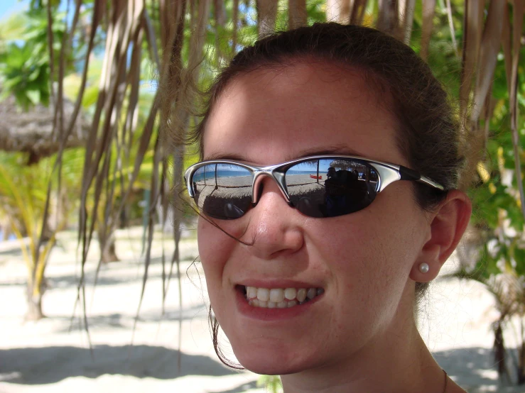 a beautiful young woman with sunglasses on smiling