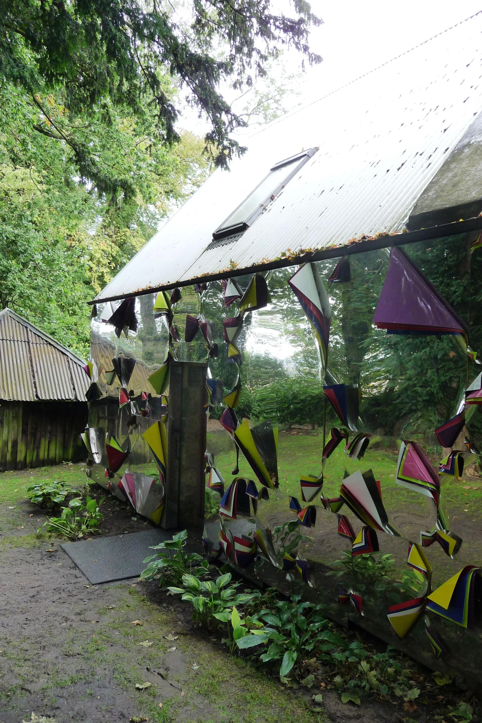 glass ornaments are hanging in the woods next to a house