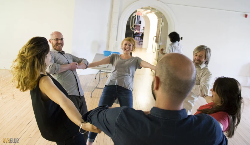 people doing dance moves in a room with wooden floor