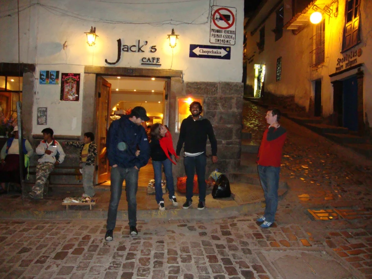 people are standing on the side walk of a building