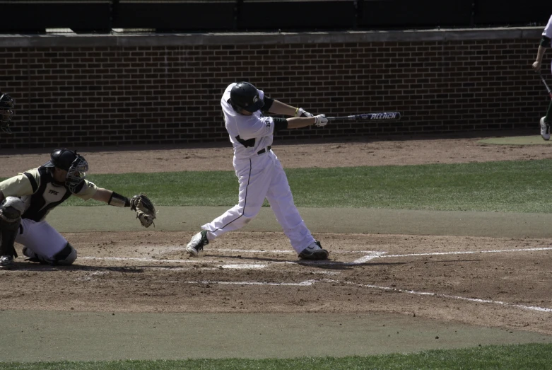 a batter at a baseball game swinging at the ball