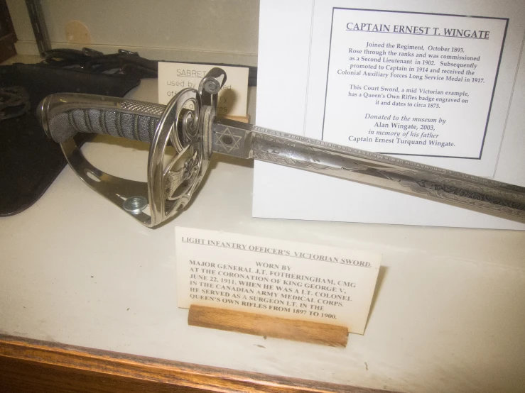 a sword, knife and memo in a museum display