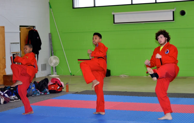 group of people in red suits practicing martial moves