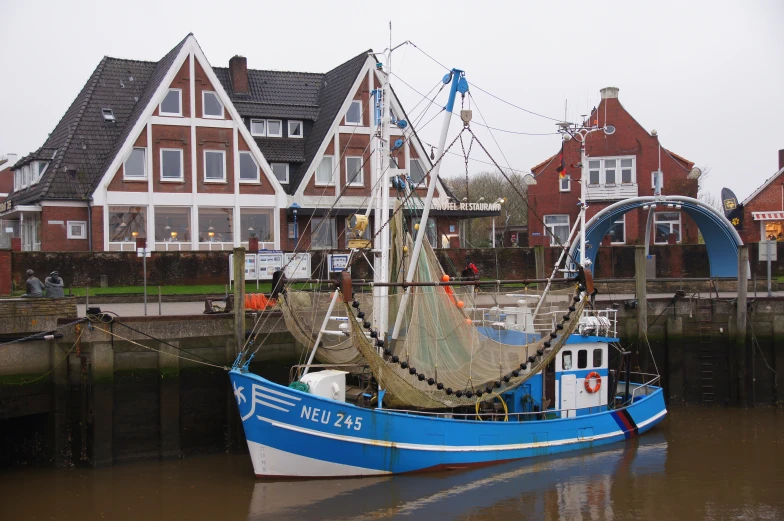 there is a small blue fishing boat in the water