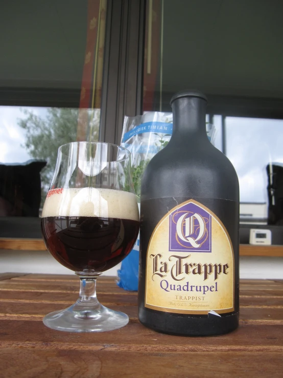 a beer bottle next to a glass of liquid