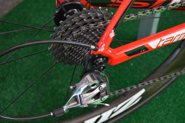the rear tire on a red bike with a chain catcher