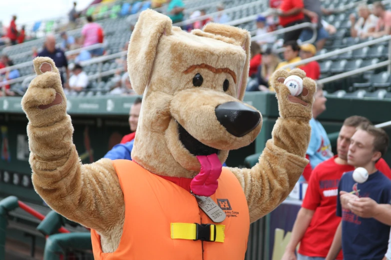 a man wearing an orange dog costume in a baseball field