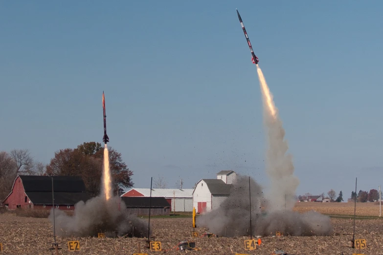 two missiles are launched near a barn and a farm