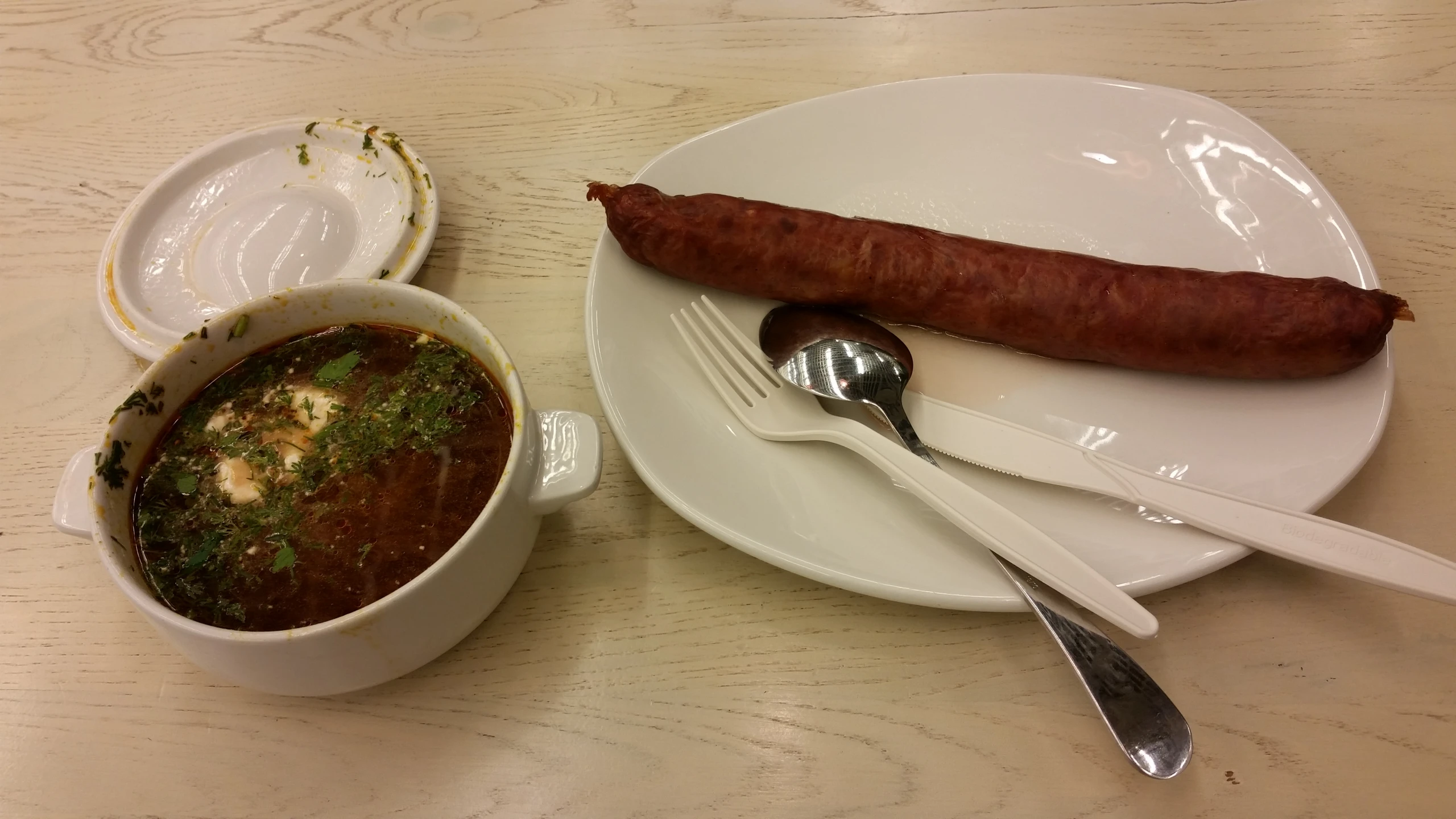 a couple of bowls filled with soup and a large sausage