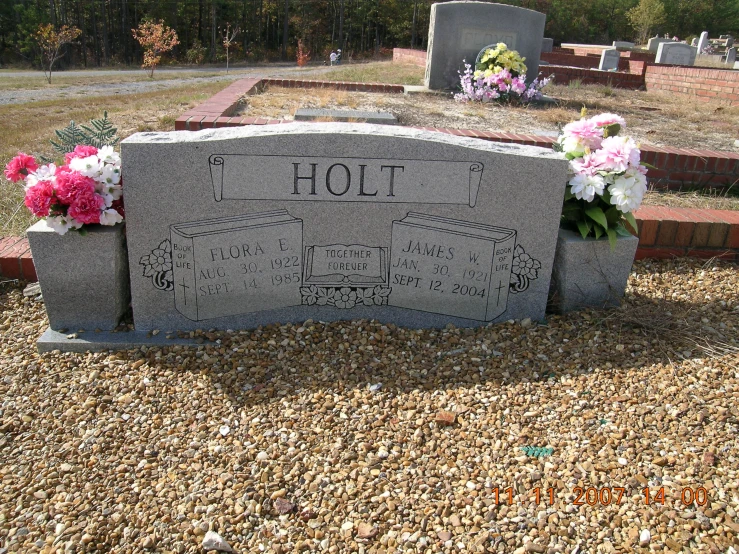 a close up of a headstone with flowers