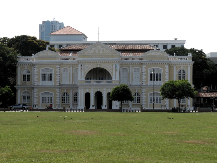 a large building that has lawn and some bushes in front