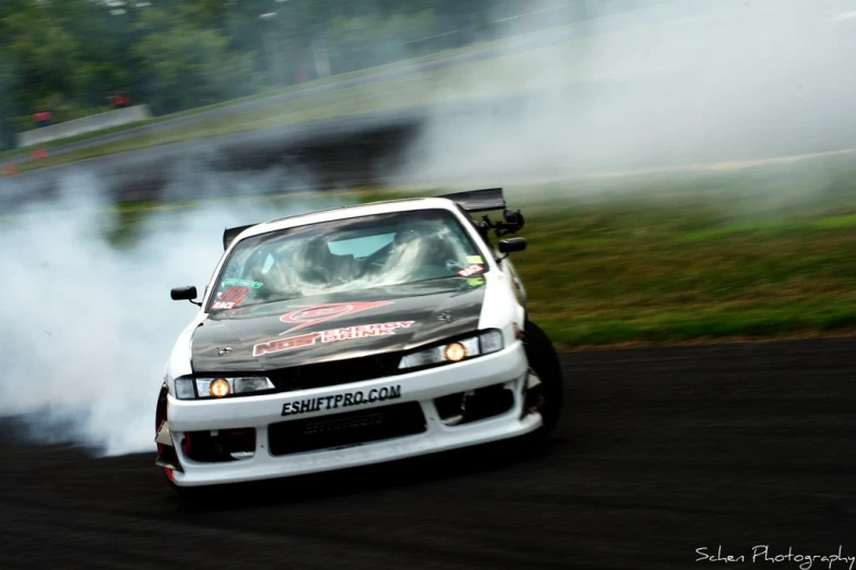 a modified car is drift racing during the day