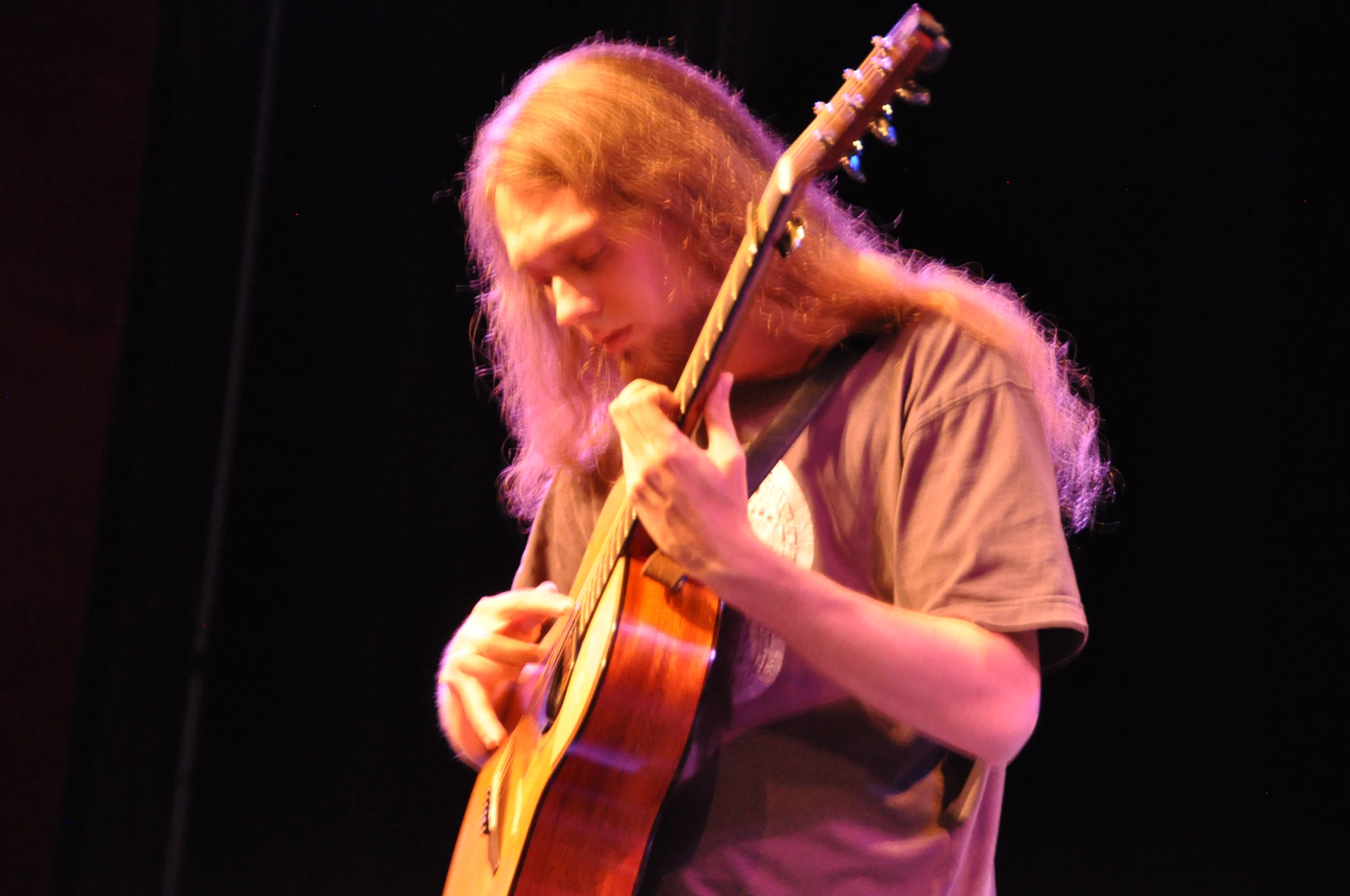 a man that is standing with a guitar